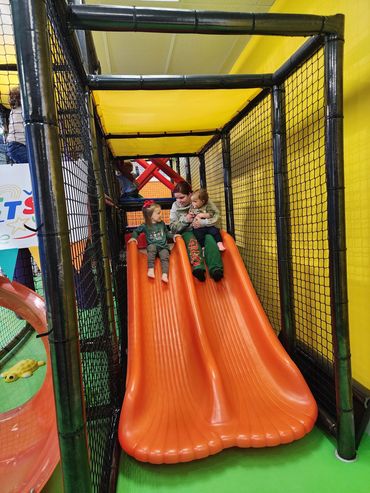 Children playing on a slide at Poppets Play Place Indoor playground West Knoxville Farragut