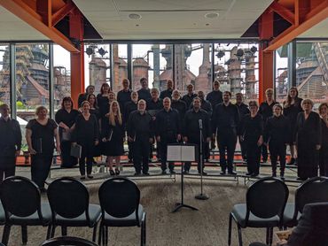 The group wearing all black and smiling for the camera in front of the Steelstacks