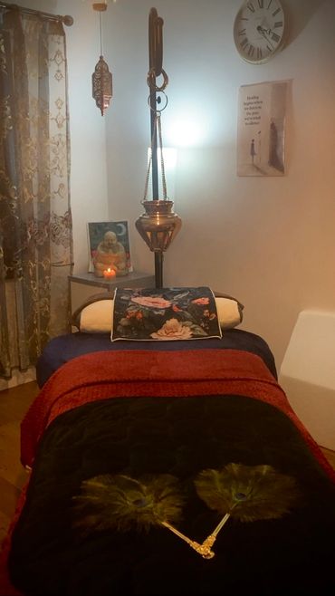 A cozy, serene massage room with dim lighting and spiritual decor.