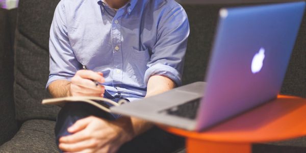 Photo of man with notebook and laptop. Image by StartupStockPhotos from Pixabay