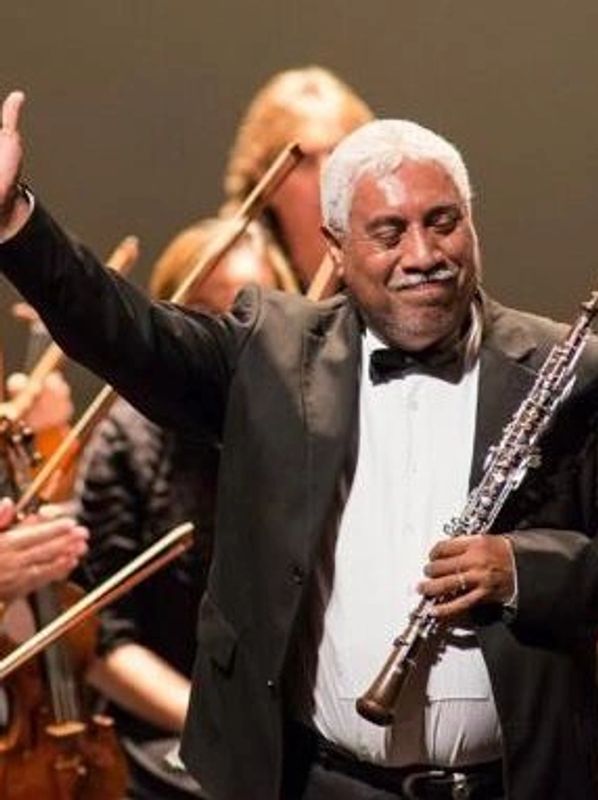 MΓΊsico con clarinete en un concierto, saludando.