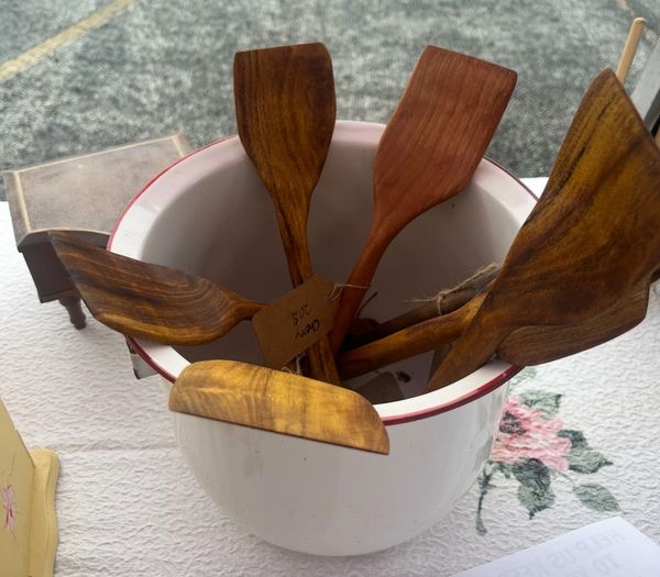 Wooden spatulas placed inside a white container on a table.