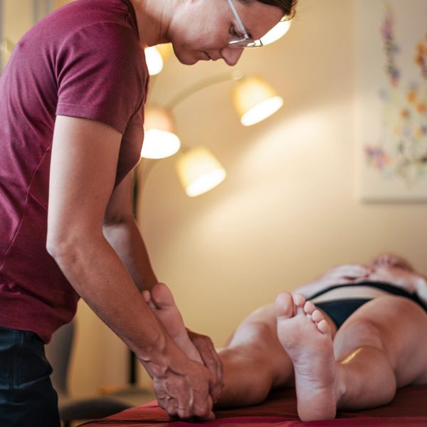 Osteopathin Ramona Prinz behandelt eine Patientin an Ihrem Fuß in ihrer Praxis in Maierhöfen.
