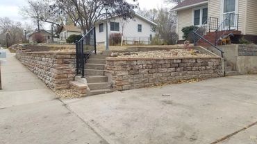 retaining wall with stairs, driveway, washed river rock