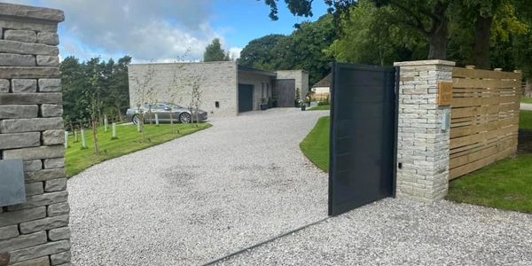 Wooden garden fence installation with trellis top in a landscaped garden