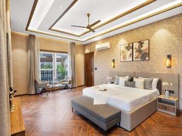 Elegant bedroom with king-size bed and seating area by window.