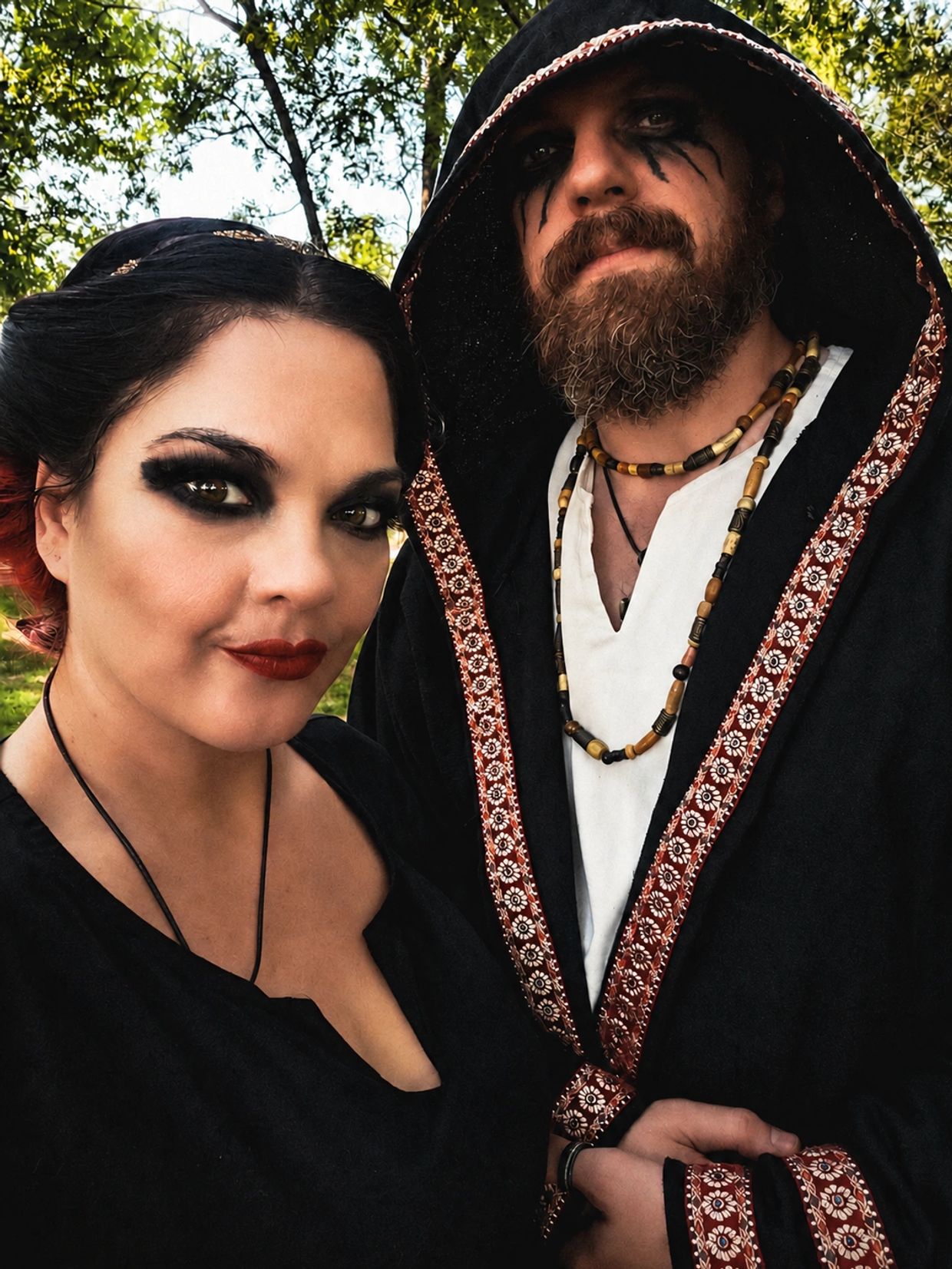Couple in dark, gothic attire with dramatic makeup.