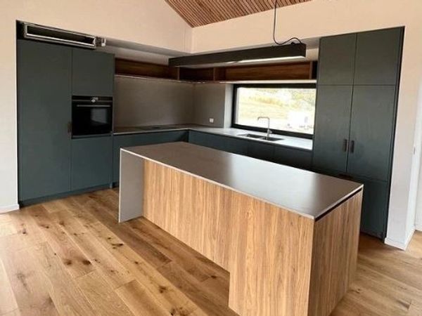 Modern kitchen with dark cabinets and wooden island.