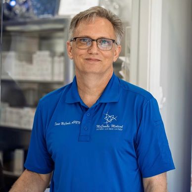 Man in blue polo shirt standing indoors.