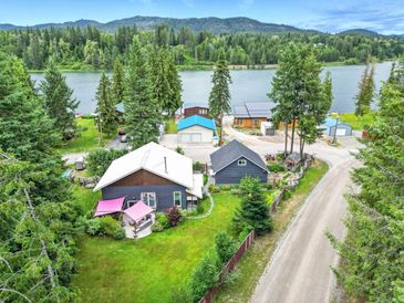 Scenic lakeside homes surrounded by lush greenery and mountains.