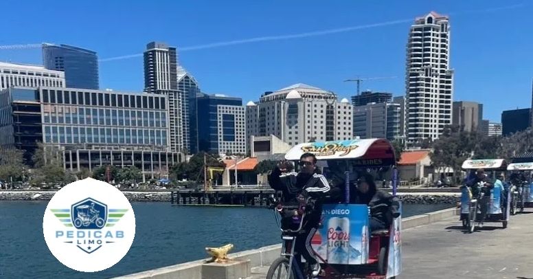 People riding pedicabs along the waterfront in a sunny city.