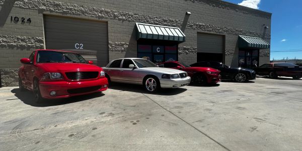 A row of parked cars outside an industrial building.