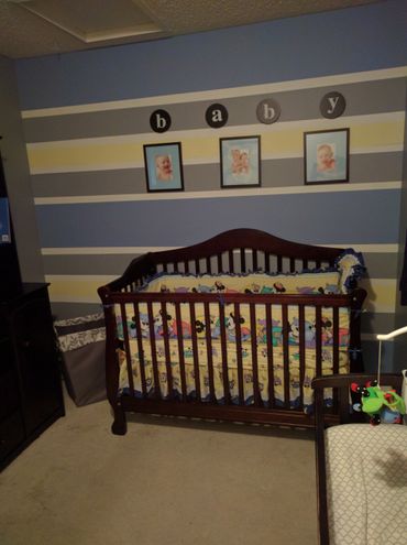 Cozy baby nursery with a dark wooden crib and colorful cartoon bedding.