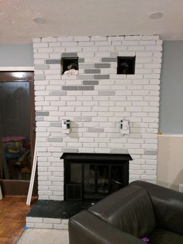 White brick fireplace with gray accents and two ventilation openings.