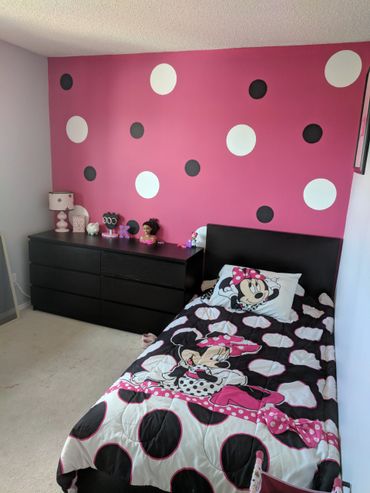 Children's bedroom with Minnie Mouse bedding and polka dot wall.