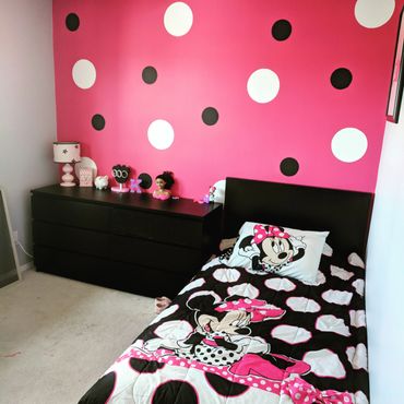 Girls bedroom with Minnie Mouse bedding and pink polka dot wall.