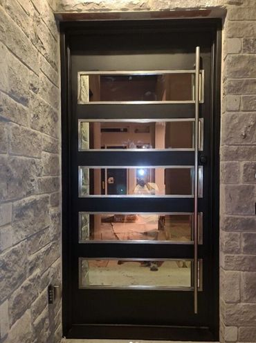 Contemporary door by porteusa 
with stainless steel door pulls and and glass frames 