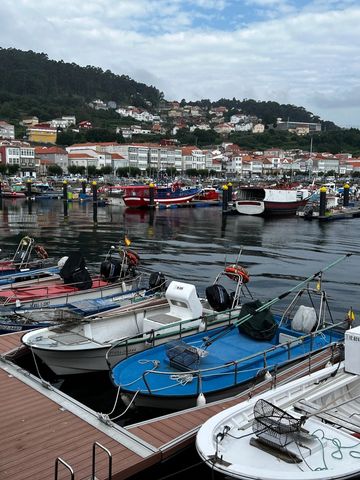 Fishing village of Muxia, Spain. Small fishing boats docked, with the village in the background. Cam