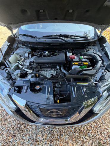 Open hood showing Nissan engine compartment.