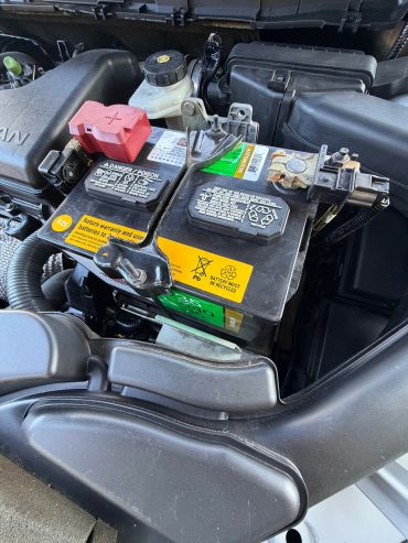 Car battery with protective covers in the engine compartment.