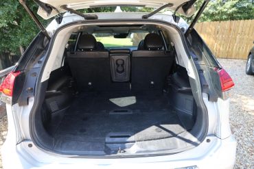 Open trunk of a white SUV with black interior.