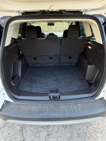 Empty SUV trunk with rear seats upright.