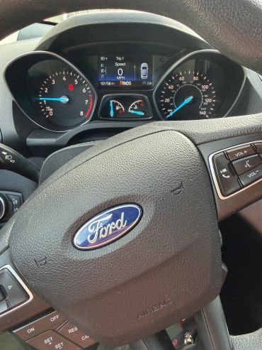 Ford car dashboard and steering wheel with controls.