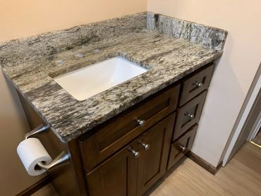 Granite countertop with sink and wooden cabinets.