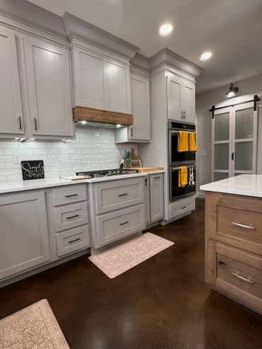 Modern kitchen with white cabinets and wooden accents.