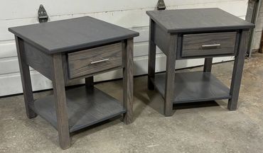 Two gray wooden side tables with drawers and lower shelves.