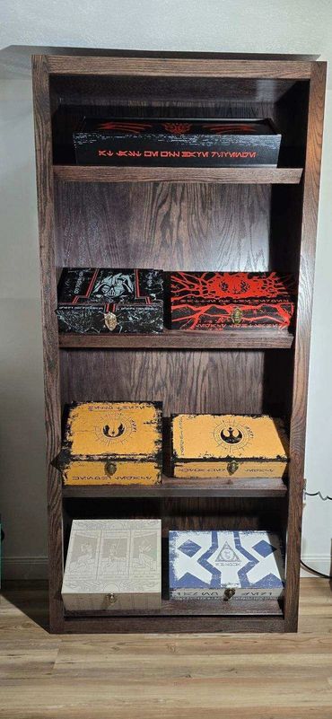 Wooden shelf with six decorated boxes featuring Star Wars designs.