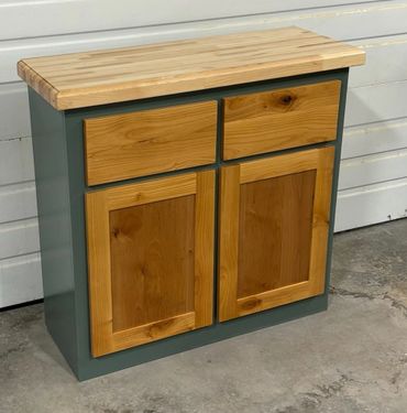 A small wooden cabinet with two drawers and two doors.