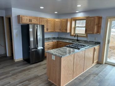 Modern kitchen with wooden cabinets and granite countertops.