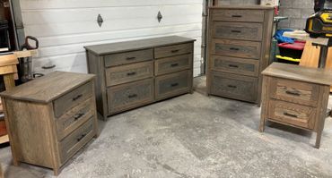 Set of four wooden dressers and nightstands in a workshop.