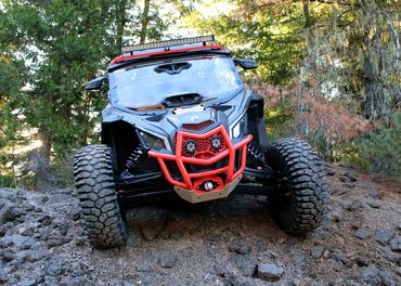 Photo of black and orange off-road vehicle in woods.