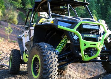 Photo of black and neon green off-road vehicle in woods.