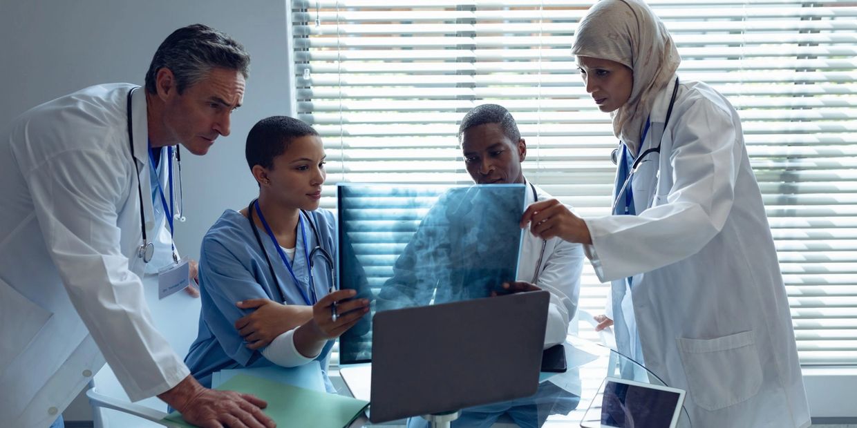 Medical team examining an X-ray together in a bright office.