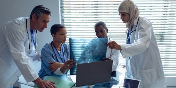 Medical team examining an X-ray together in a bright office.