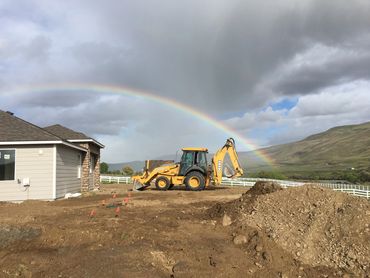 BACKHOE WITH RAINBOW TO SEPTIC SYSTEM. PROSSER, WA