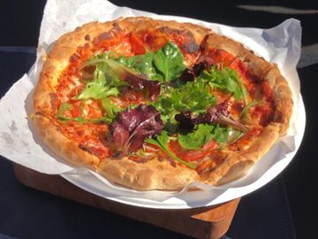 veggie delight pizza with seasoned arugula.