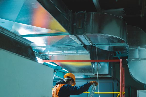 Worker inspecting ductwork