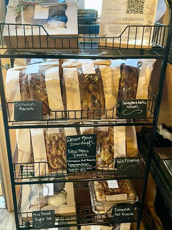 Bakery shelf with various sourdough breads and new menu items labeled.