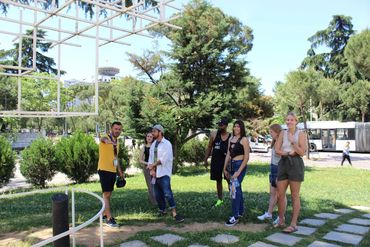 Free walking tour in Tirana: enthusiastic travelers gather around their guide,