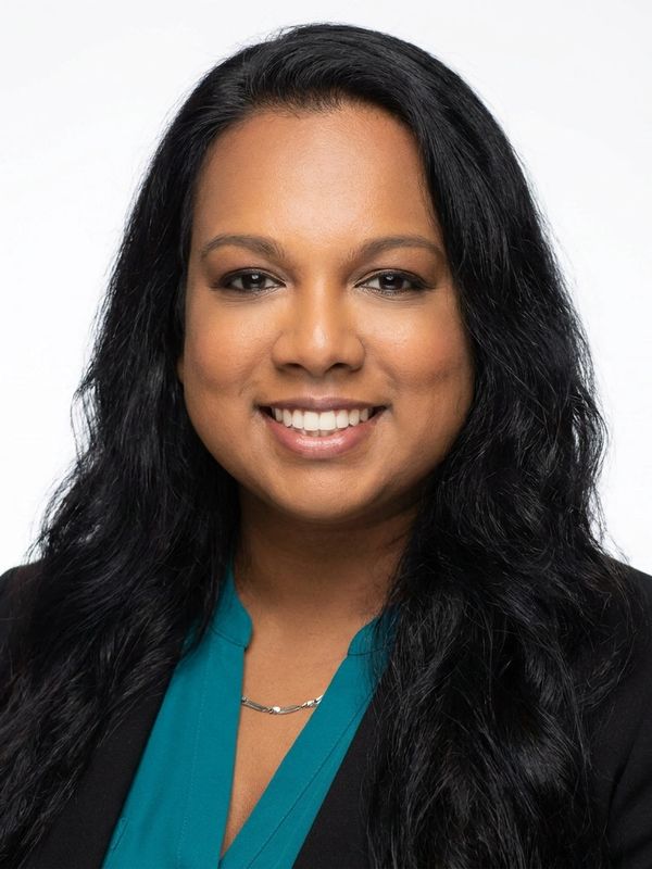 Professional woman smiling with long black hair.