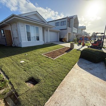 Newly laid sod in front yard of a suburban house under sunny weather.