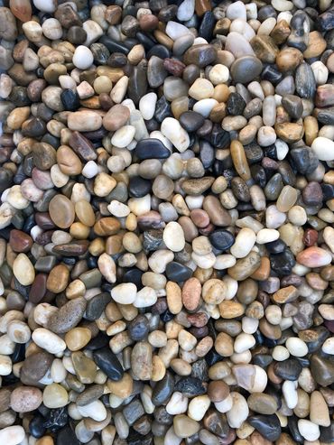 Close-up of smooth, multicolored pebbles arranged closely together.