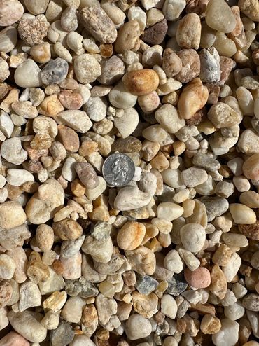 Various small, irregularly shaped stones with a quarter coin for size reference.