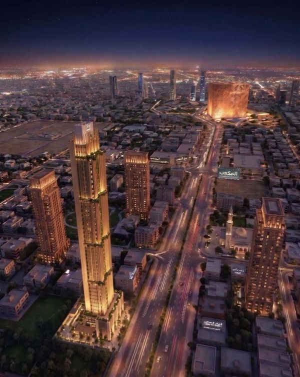Night aerial view of a city with prominent illuminated buildings and busy roads.