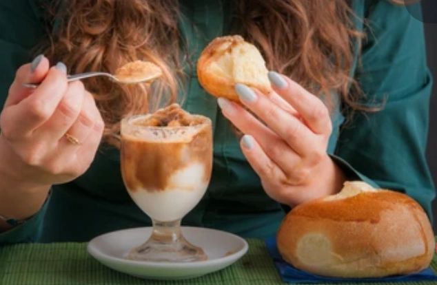 Lady eating Sicilian brioche with gelato.