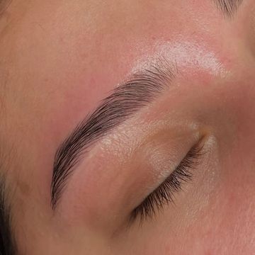 Well-groomed, natural eyebrow with closed eye.